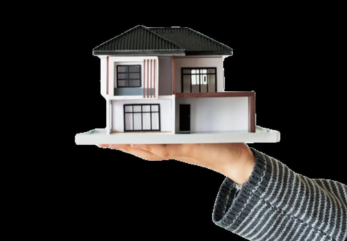 A hand holding a model of a modern house